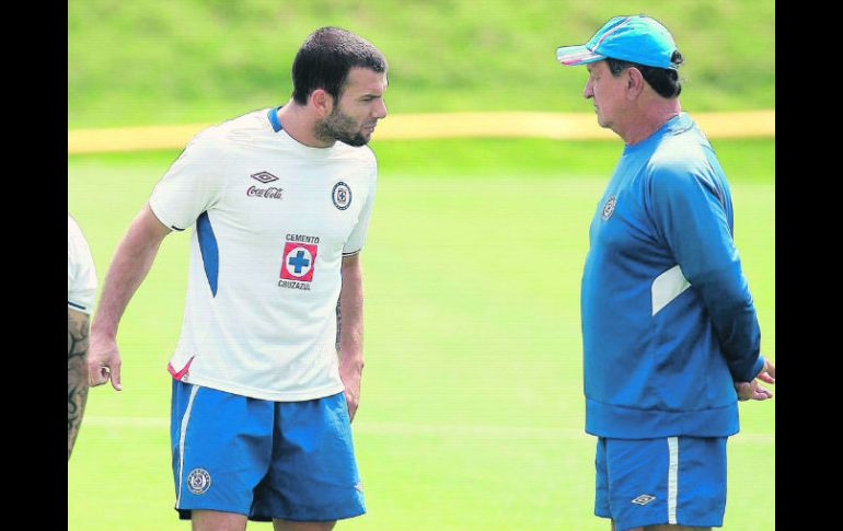 El técnico Enrique “Ojitos” Meza (derecha) platica con su delantero Emanuel Villa, durante el entrenamiento en La Noria. MEXSPORT  /