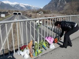 Una mujer deja un ramo de flores en un puente cercano al túnel donde se accidentó el autobús. EFE  /