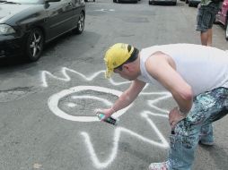 Aprovechando las dimensiones del bache, un ciudadano plasma un sonriente sol en el asfalto  /