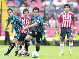 El veterano Israel López (5) del Querétaro, conduce el esférico seguido por el rojiblanco Carlos Fierro. MEXSPORT  /