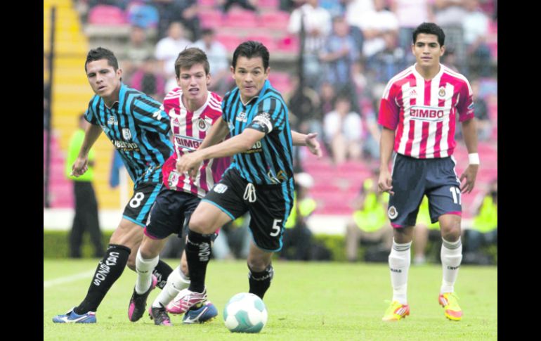 El veterano Israel López (5) del Querétaro, conduce el esférico seguido por el rojiblanco Carlos Fierro. MEXSPORT  /