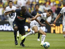 Christian Benitez (I) del América lucha por el balón con Luis Fuentes de Pumas durante el juego. EFE  /