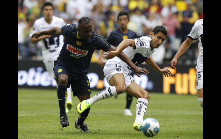 Christian Benitez (I) del América lucha por el balón con Luis Fuentes de Pumas durante el juego. EFE  /