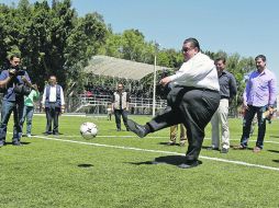 El alcalde de Guadalajara, Francisco Ayón, prueba la cancha con pasto sintético recién inaugurada.  /