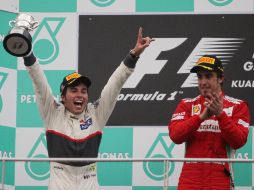 El ''Checo'' Pérez (izq.) celebra junto a Fernando Alonso el haber obtenido el segundo lugar en el Gran Premio de Malasia. AP  /