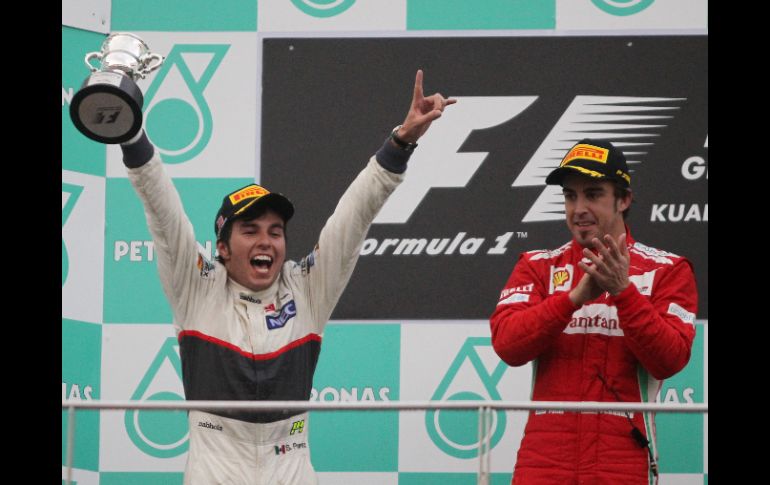 El ''Checo'' Pérez (izq.) celebra junto a Fernando Alonso el haber obtenido el segundo lugar en el Gran Premio de Malasia. AP  /