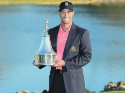 Tiger Woods exhibe el trofeo que conquistó en el Torneo Arnold Palmer Invitational. AFP  /