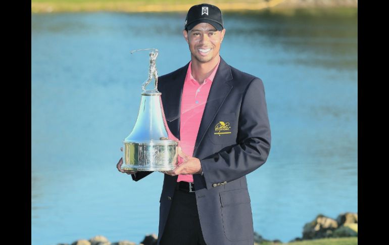 Tiger Woods exhibe el trofeo que conquistó en el Torneo Arnold Palmer Invitational. AFP  /