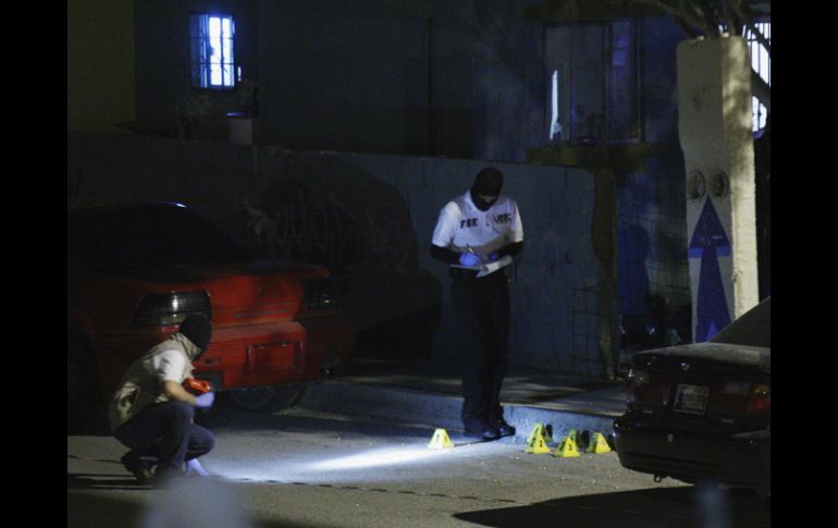 Los forenses de Ciudad Juárez analizan la escena del crimen. REUTERS  /