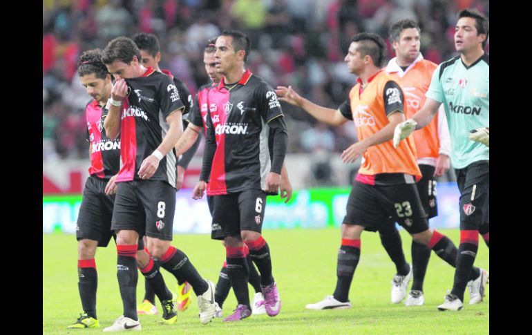 Jugadores del Atlas se retiran de la cancha del Estadio Jalisco, tras el empate sin anotaciones.  /