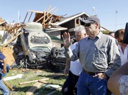 Rick Perry (gafas y gorra) dijo que busca acelerar la entrega de dinero federal para las reparaciones. AP  /