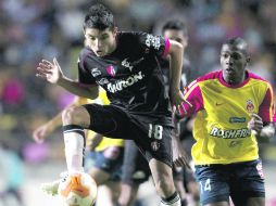 El tapatío Arturo Paganoni, del Atlas, conduce un balón seguido de Edinson, de Monarcas. MEXSPORT  /