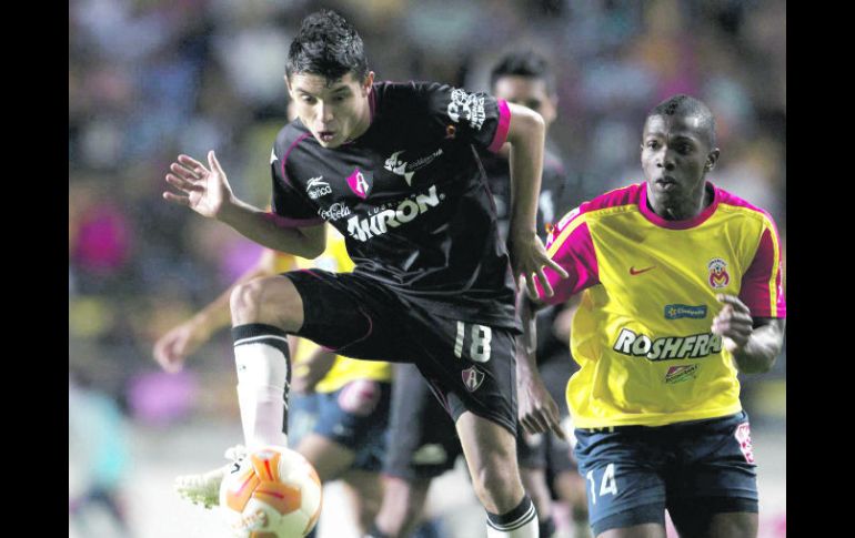 El tapatío Arturo Paganoni, del Atlas, conduce un balón seguido de Edinson, de Monarcas. MEXSPORT  /