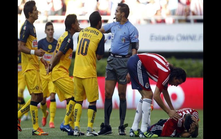 Jugadores de América (I) discuten una decisión del árbitro Marco Antonio Rodríguez (C) a favor del equipo Chivas. EFE  /