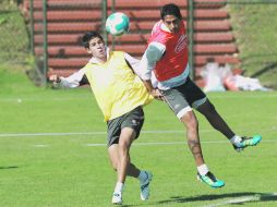 Jahir Barraza y Hugo Rodríguez luchan por la posesión de la pelota en la práctica rojinegra.  /