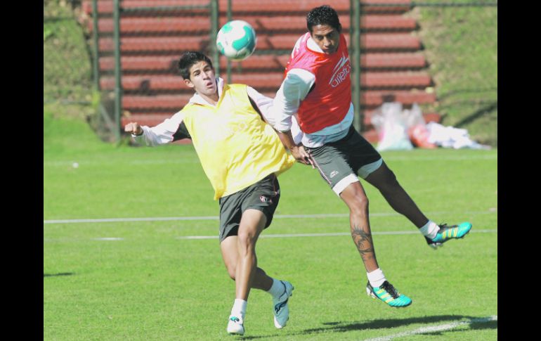 Jahir Barraza y Hugo Rodríguez luchan por la posesión de la pelota en la práctica rojinegra.  /