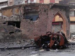 Un coche y unos edificios dañados en el barrio de Jorat Al-Shayyah, en Homs. EFE  /