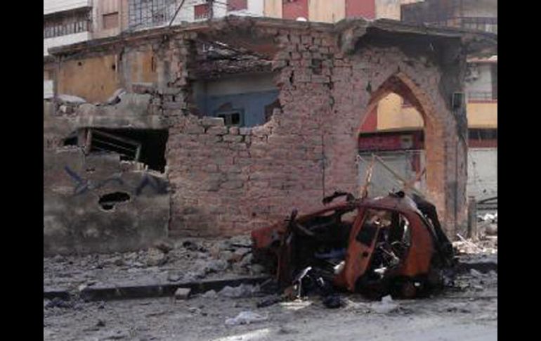 Un coche y unos edificios dañados en el barrio de Jorat Al-Shayyah, en Homs. EFE  /