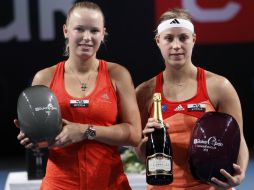 La tenista danesa Caroline Wozniacki (izquierda), y la alemana Angelique Kerber posan con sus trofeos. AP  /