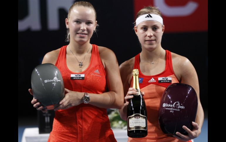 La tenista danesa Caroline Wozniacki (izquierda), y la alemana Angelique Kerber posan con sus trofeos. AP  /