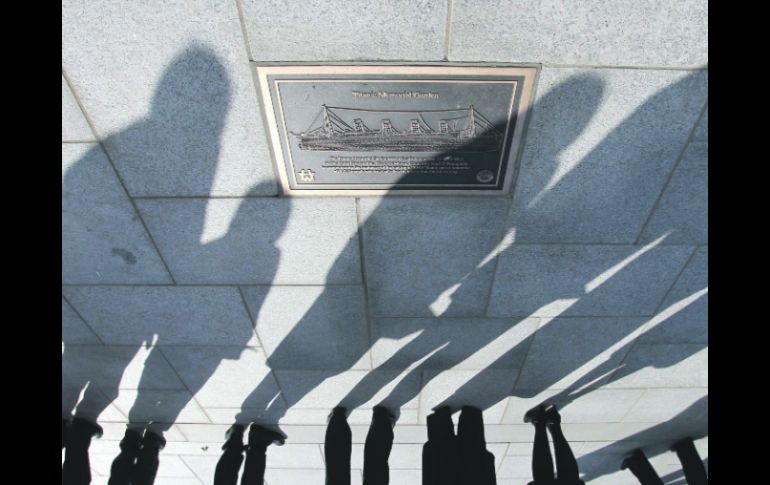 UN MINUTO DE SILENCIO. Sombras de familiares se funden en la placa alusiva a las personas que murieron en el hundimiento del Titanic.  /