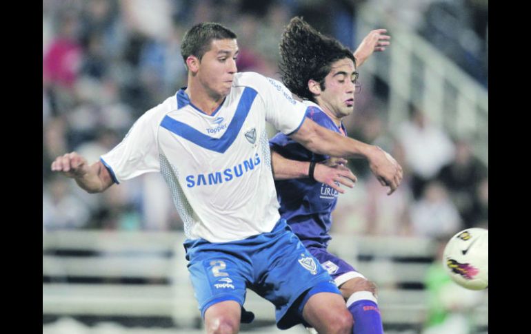 Fernando Tovio, del Vélez, disputa un balón con Matías Britos, del Sporting uruguayo. AP  /