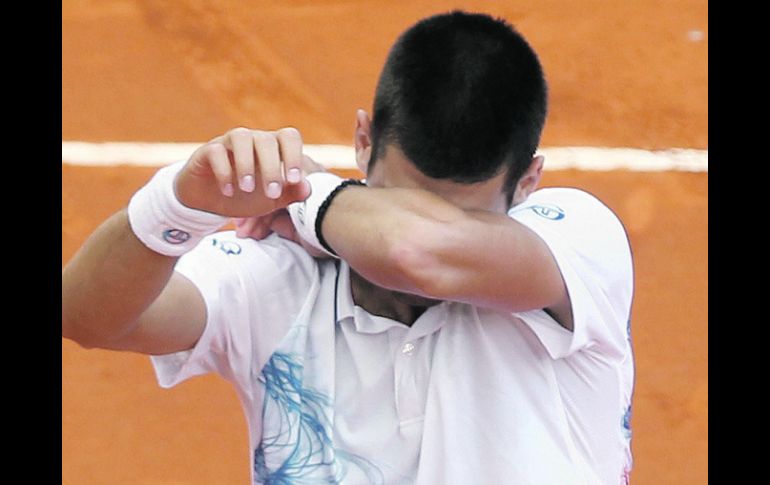 En el momento en que ganó el último punto, el tenista serbio Novak Djokovic soltó la raqueta y cubrió su rostro con los brazos.AFP  /