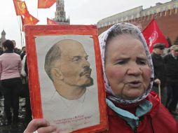 Una mujer sostiene una imagen de Vladimir Lenin durante una ofrenda floral para conmemorar su 142 cumpleaños. EFE  /