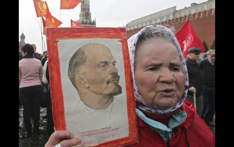 Una mujer sostiene una imagen de Vladimir Lenin durante una ofrenda floral para conmemorar su 142 cumpleaños. EFE  /