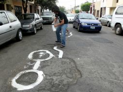 La dinámica es pintar de blanco una figura para encerrar el bache. ARCHIVO  /