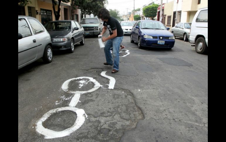 La dinámica es pintar de blanco una figura para encerrar el bache. ARCHIVO  /