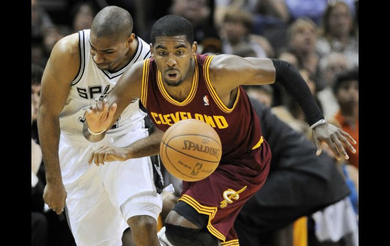 Kyrie Iriving de Cleveland (der) y de los Spurs Gary Neal (izq) se disputan el balón durante la segunda mitad del juego. AP  /