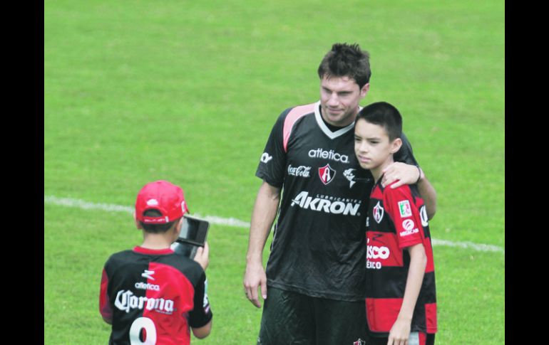 El capitán rojinegro, el zaguero argentino Leandro Cufré, se toma una fotografía con uno de los niños que asistieron ayer a la práctica  /