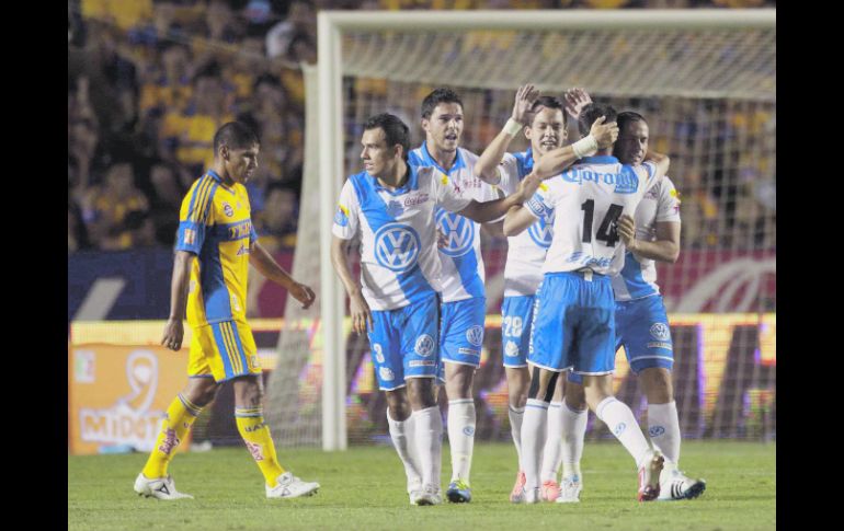 Jugadores de la Franja festejan el triunfo, ante la tristeza de los felinos. MEXSPORT  /