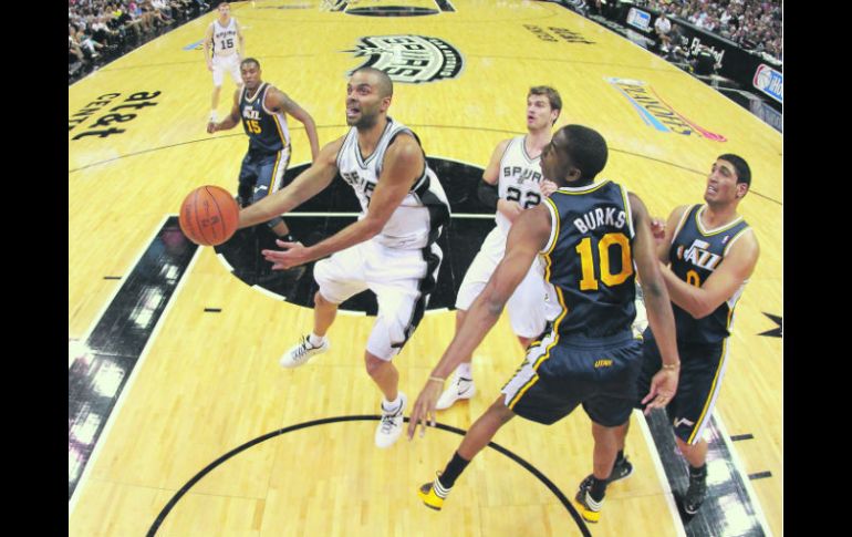 El francés Tony Parker (centro), de los Spurs, penetra la defensiva de Utah para ejecutar un tiro. AFP  /