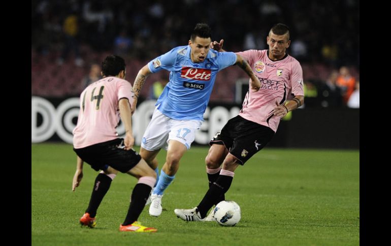 Hamsik (centro) del Nápoles se mete ante la marca de dos jugadores del Palermo. EFE  /