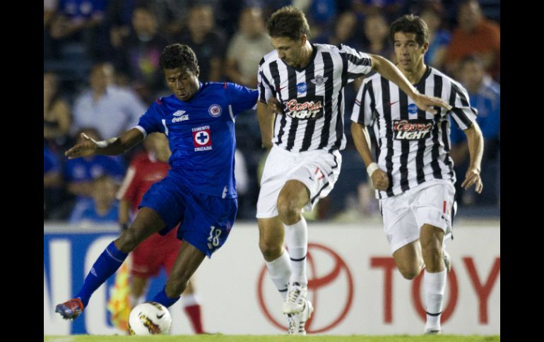 Francinilson Santos (i) de Cruz Azul pelea el balón con jugadores de Libertad. AP  /