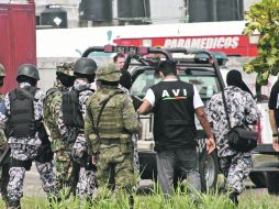 Policías navales y militares resguardan la zona donde fueron arrojadas las bolsas con los cuerpo.AFP  /