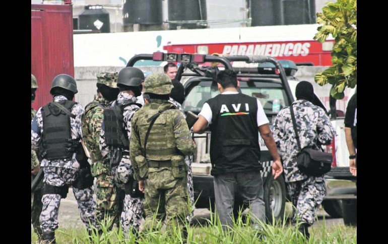 Policías navales y militares resguardan la zona donde fueron arrojadas las bolsas con los cuerpo.AFP  /