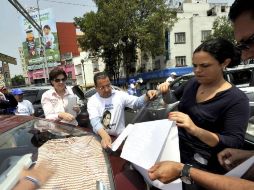 Mariana Gómez del Campo repartió volantes y pegó medallones en automóviles. NOTIMEX  /