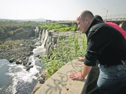 Enrique Alfaro observa las aguas contaminadas del Río Santiago.  /