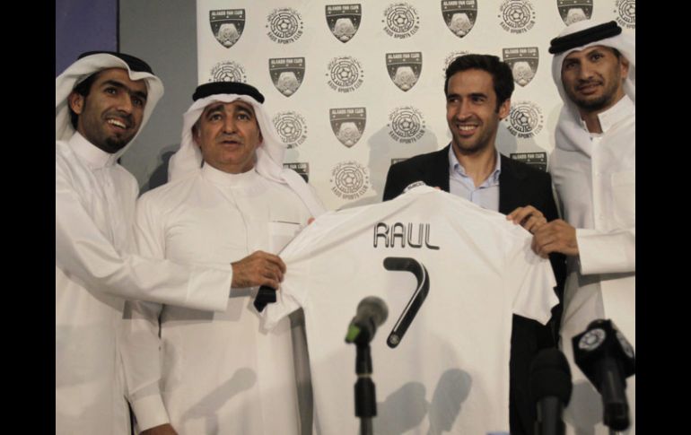 Raúl gonzález posa con la playera y los directivos de su nuevo equipo. EFE  /