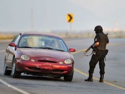 Policías controlan la zona donde fueron hallados al menos 49 cuerpos en Cadereyta, NL. EFE  /