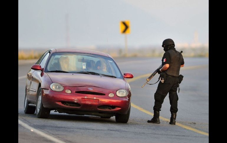 Policías controlan la zona donde fueron hallados al menos 49 cuerpos en Cadereyta, NL. EFE  /