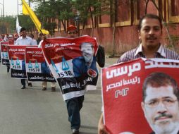 Los partidarios del candidato egipcio en las elecciones presidenciales, Mohammed Mursi, sostienen sus carteles de la campaña. AFP  /