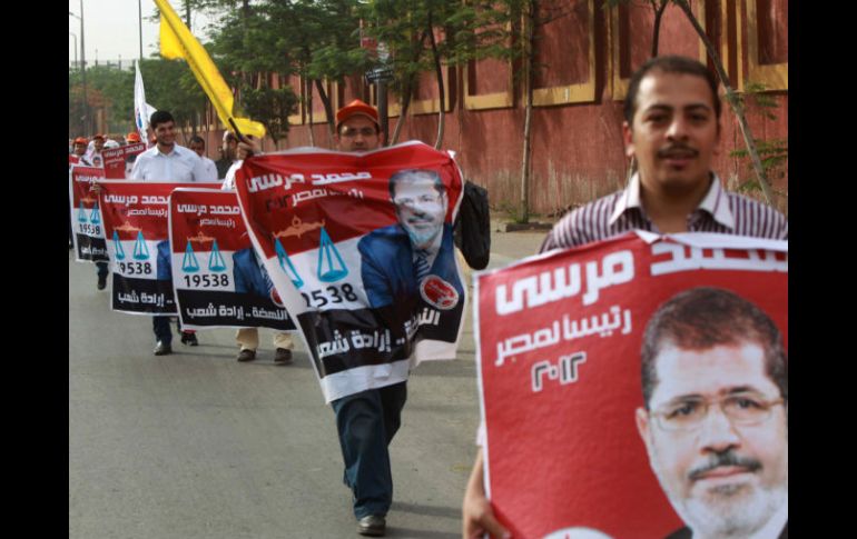 Los partidarios del candidato egipcio en las elecciones presidenciales, Mohammed Mursi, sostienen sus carteles de la campaña. AFP  /