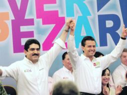 Manuel Espino (izquierda), levanta la mano del candidato priista, Enrique Peña Nieto, tras declararle su apoyo. EL UNIVERSAL  /