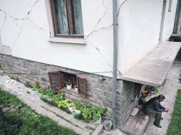 Un hombre aguarda afuera de su casa que resultó dañada cerca del centro de la ciudad de Pernik, al occidente de Bulgaria. AFP  /