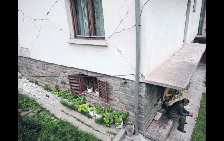 Un hombre aguarda afuera de su casa que resultó dañada cerca del centro de la ciudad de Pernik, al occidente de Bulgaria. AFP  /