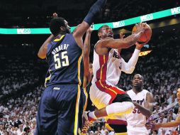 Dwyane Wade (centro), del Miami Heat, penetra la defensiva de Indiana y dispara a al canasta. AFP  /